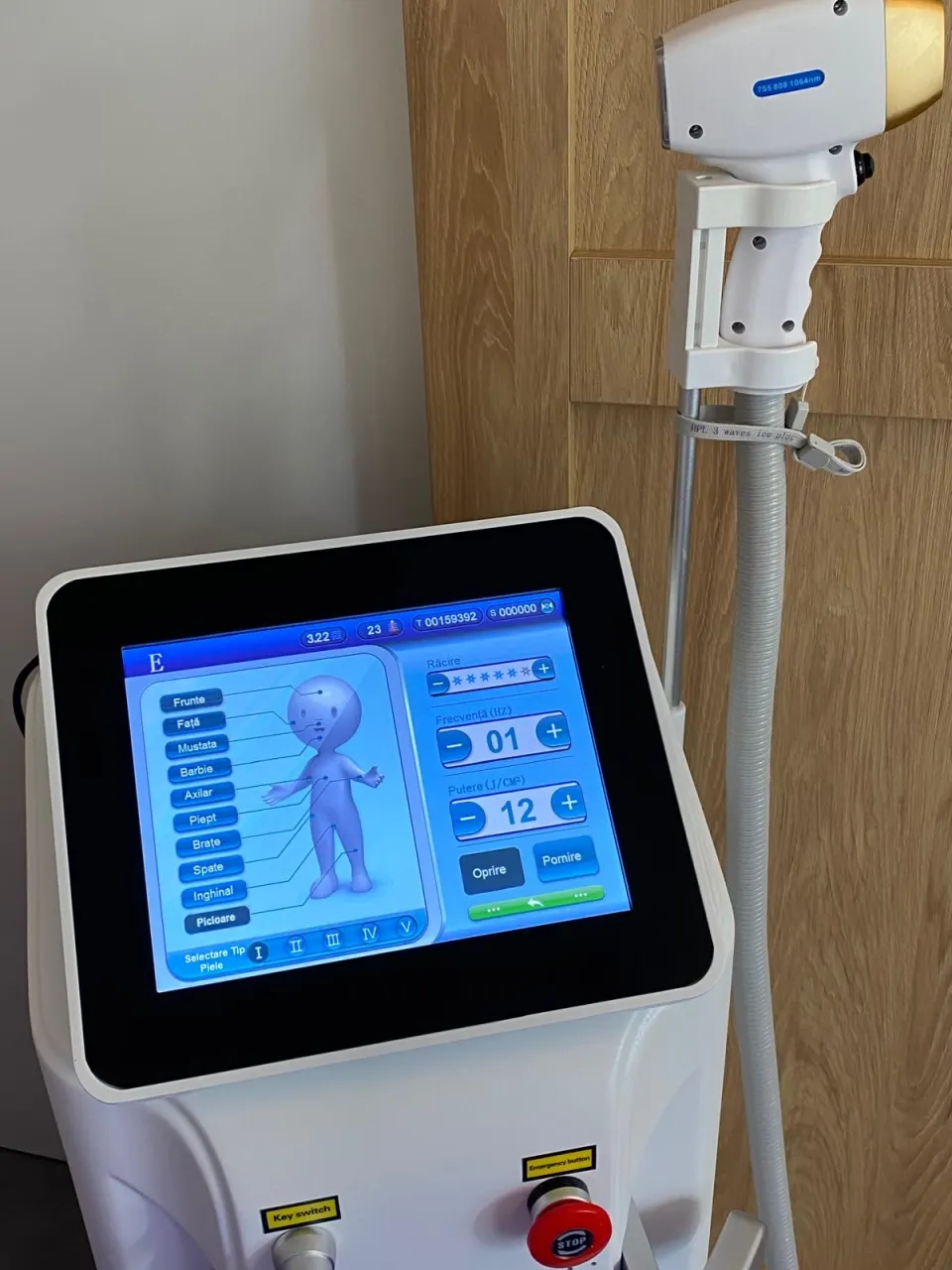 Laserul SmARTy cu ecranul de zone și setări, lângă capul de tratament prins în suport